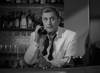 A black and white photo of a man talking on a phone