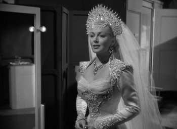 Movie still from “The Bad and the Beautiful” (1952), directed by Vincente Minnelli – A black and white photo of a woman in a wedding dress; Medium shot, Over the shoulder angle