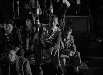 Movie still from “The Bad and the Beautiful” (1952), directed by Vincente Minnelli – Black and white photograph of men in suits and ties; Medium shot, High angle
