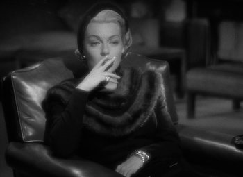 Movie still from “The Bad and the Beautiful” (1952), directed by Vincente Minnelli – A black and white photo of a woman smoking a cigarette; Medium shot, High angle