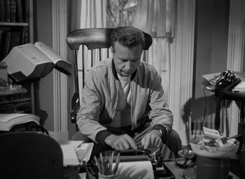 Movie still from “The Bad and the Beautiful” (1952), directed by Vincente Minnelli – A man sitting at a desk typing on a typewriter; Medium shot, Low angle