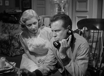 Movie still from “The Bad and the Beautiful” (1952), directed by Vincente Minnelli – A man and a woman sitting in a chair talking on a phone; Medium shot, Low angle