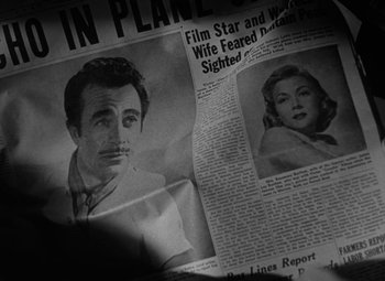 Movie still from “The Bad and the Beautiful” (1952), directed by Vincente Minnelli – An old photo of a man and a woman in front of a newspaper; Extreme Close Up shot, High angle