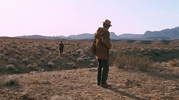 Movie still from “The Ballad of Cable Hogue” (1970), directed by Sam Peckinpah – A man with a backpack and hat is standing in the desert; Extreme Wide shot, Low angle