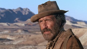 Movie still from “The Ballad of Cable Hogue” (1970), directed by Sam Peckinpah – A person wearing a hat with mountains in the background; Close Up shot, Low angle