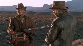Movie still from “The Ballad of Cable Hogue” (1970), directed by Sam Peckinpah – Two men standing in a field with a gun; Medium shot, Over the shoulder angle
