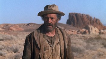 Movie still from “The Ballad of Cable Hogue” (1970), directed by Sam Peckinpah – A man with a hat on standing in the desert; Medium shot, Low angle