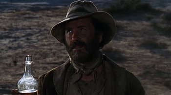 Movie still from “The Ballad of Cable Hogue” (1970), directed by Sam Peckinpah – A man with a beard wearing a hat; Close Up shot, Low angle