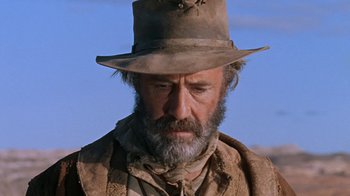 Movie still from “The Ballad of Cable Hogue” (1970), directed by Sam Peckinpah – A man with a beard and a hat on; Close Up shot, Low angle