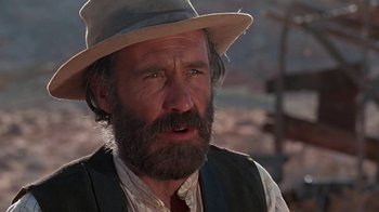 Movie still from “The Ballad of Cable Hogue” (1970), directed by Sam Peckinpah – An old man with a beard wearing a hat and vest; Close Up shot, Low angle