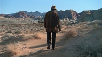 Movie still from “The Ballad of Cable Hogue” (1970), directed by Sam Peckinpah – A man walking on a dirt path in the desert; Wide shot, Low angle