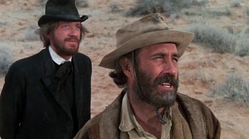 Movie still from “The Ballad of Cable Hogue” (1970), directed by Sam Peckinpah – A man in a cowboy hat is standing next to another man in a cowboy hat; Close Up shot, Low angle