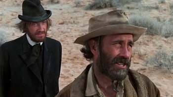 Movie still from “The Ballad of Cable Hogue” (1970), directed by Sam Peckinpah – A man in a cowboy hat standing next to another man in a suit; Close Up shot, Over the shoulder angle