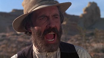 Movie still from “The Ballad of Cable Hogue” (1970), directed by Sam Peckinpah – A man with a beard and a hat is yelling; Close Up shot, Low angle