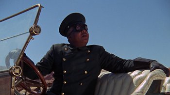 Movie still from “The Ballad of Cable Hogue” (1970), directed by Sam Peckinpah – A man in a uniform sitting on a boat; Close Up shot, Low angle
