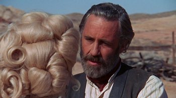 Movie still from “The Ballad of Cable Hogue” (1970), directed by Sam Peckinpah – An old man with a beard looking at a woman's hair in the desert; Close Up shot, Over the shoulder angle