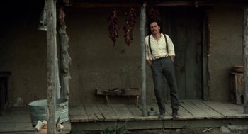 Movie still from “The Ballad of Gregorio Cortez” (1982), directed by Robert M. Young – A man standing on the porch of a house; Wide shot, Low angle