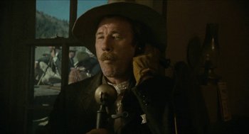 Movie still from “The Ballad of Gregorio Cortez” (1982), directed by Robert M. Young – A man in a hat talking on a phone; Close Up shot, Low angle