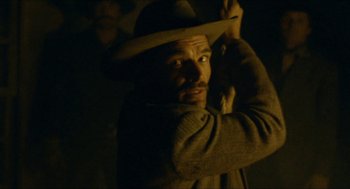 Movie still from “The Ballad of Gregorio Cortez” (1982), directed by Robert M. Young – A man with a hat is holding his hat up; Medium shot, Low angle