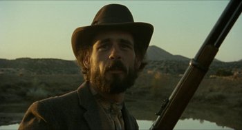 Movie still from “The Ballad of Gregorio Cortez” (1982), directed by Robert M. Young – A man with a beard wearing a hat and holding a rifle; Close Up shot, Low angle