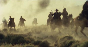 Movie still from “The Ballad of Gregorio Cortez” (1982), directed by Robert M. Young – A group of men riding horses through a dusty field; Extreme Wide shot, Low angle