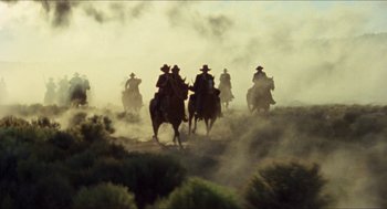 Movie still from “The Ballad of Gregorio Cortez” (1982), directed by Robert M. Young – A group of men riding horses through a dusty field; Extreme Wide shot, Low angle