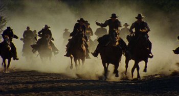Movie still from “The Ballad of Gregorio Cortez” (1982), directed by Robert M. Young – A group of men on horses running through the dirt; Extreme Wide shot, Low angle