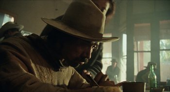 Movie still from “The Ballad of Gregorio Cortez” (1982), directed by Robert M. Young – A man wearing a hat is writing on a piece of paper; Close Up shot, Low angle