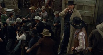 Movie still from “The Ballad of Gregorio Cortez” (1982), directed by Robert M. Young – A group of men sitting on the side of a road; Wide shot, High angle