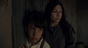 Movie still from “The Ballad of Gregorio Cortez” (1982), directed by Robert M. Young – A woman standing next to a young boy in front of a wall; Close Up shot, Low angle
