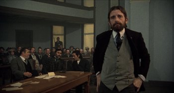 Movie still from “The Ballad of Gregorio Cortez” (1982), directed by Robert M. Young – A man standing in front of a group of people; Medium shot, Low angle