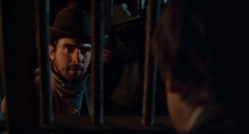 Movie still from “The Ballad of Gregorio Cortez” (1982), directed by Robert M. Young – A man with a beard and a hat looking through a fence; Close Up shot, Over the shoulder angle