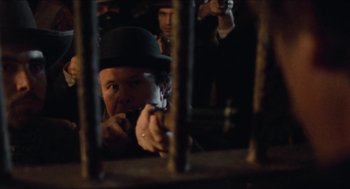 Movie still from “The Ballad of Gregorio Cortez” (1982), directed by Robert M. Young – A man in a hat is holding a cell phone in his hand; Close Up shot, Over the shoulder angle