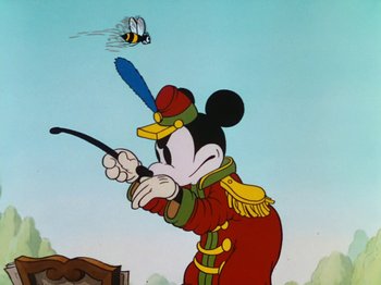 Movie still from “The Band Concert” (1935), directed by Wilfred Jackson – A painting of a mickey mouse in a uniform holding a whip; Medium shot, Low angle