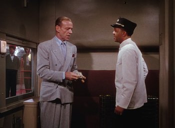 Movie still from “The Band Wagon” (1953), directed by Vincente Minnelli – A man in a suit talks to another man in a white shirt; Medium shot, Low angle