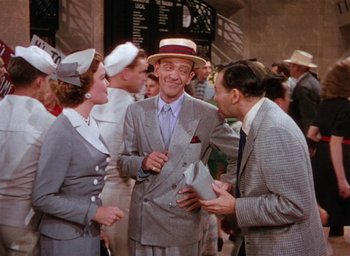 Movie still from “The Band Wagon” (1953), directed by Vincente Minnelli – A group of people standing next to each other; Medium shot, Over the shoulder angle