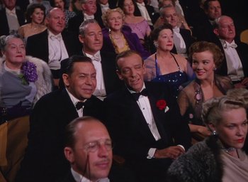 Movie still from “The Band Wagon” (1953), directed by Vincente Minnelli – A group of people sitting in a room; Medium shot, High angle