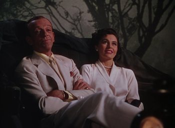 Movie still from “The Band Wagon” (1953), directed by Vincente Minnelli – A man and a woman sitting next to each other on a couch; Medium shot, Low angle