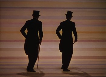 Movie still from “The Band Wagon” (1953), directed by Vincente Minnelli – A couple of men standing next to each other; Medium shot, Low angle