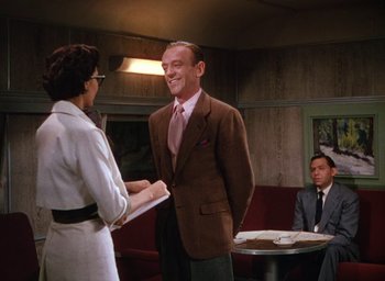 Movie still from “The Band Wagon” (1953), directed by Vincente Minnelli – A man in a brown jacket and a woman in a white dress; Medium shot, Over the shoulder angle