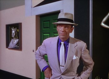 Movie still from “The Band Wagon” (1953), directed by Vincente Minnelli – A man in a suit and hat standing in front of a green door; Medium shot, Low angle