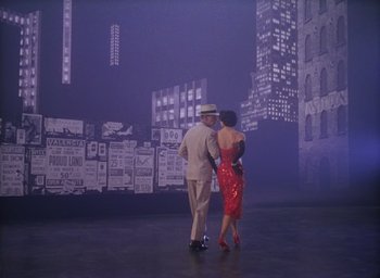 Movie still from “The Band Wagon” (1953), directed by Vincente Minnelli – A man and a woman are dancing in front of a city skyline; Wide shot, High angle