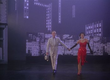 Movie still from “The Band Wagon” (1953), directed by Vincente Minnelli – A man and a woman are walking on a stage; Wide shot, Low angle