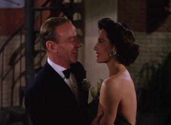 Movie still from “The Band Wagon” (1953), directed by Vincente Minnelli – A man and a woman smiling at each other; Medium shot, High angle