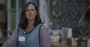 Movie still from “Horse Girl” (2020), directed by Jeff Baena – A woman in a hospital gown with a name tag; Close Up shot, Over the shoulder angle