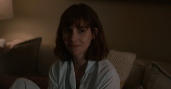 Movie still from “Horse Girl” (2020), directed by Jeff Baena – A woman sitting on a couch in a room; Close Up shot, Over the shoulder angle