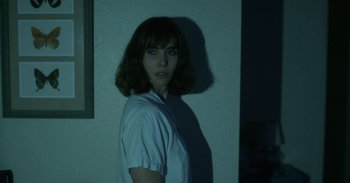 Movie still from “Horse Girl” (2020), directed by Jeff Baena – A woman standing in front of a white wall; Close Up shot, Over the shoulder angle