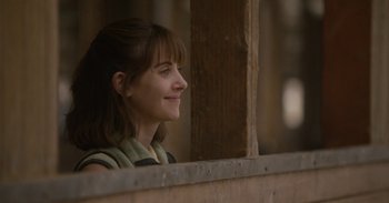 Movie still from “Horse Girl” (2020), directed by Jeff Baena – A woman looking out of a window at a building; Close Up shot, Over the shoulder angle