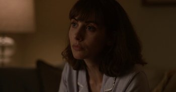 Movie still from “Horse Girl” (2020), directed by Jeff Baena – A person sitting in a dark room; Close Up shot, Over the shoulder angle