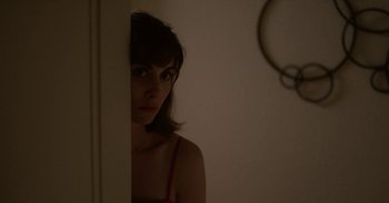 Movie still from “Horse Girl” (2020), directed by Jeff Baena – A woman standing next to a mirror in a room; Close Up shot, Over the shoulder angle